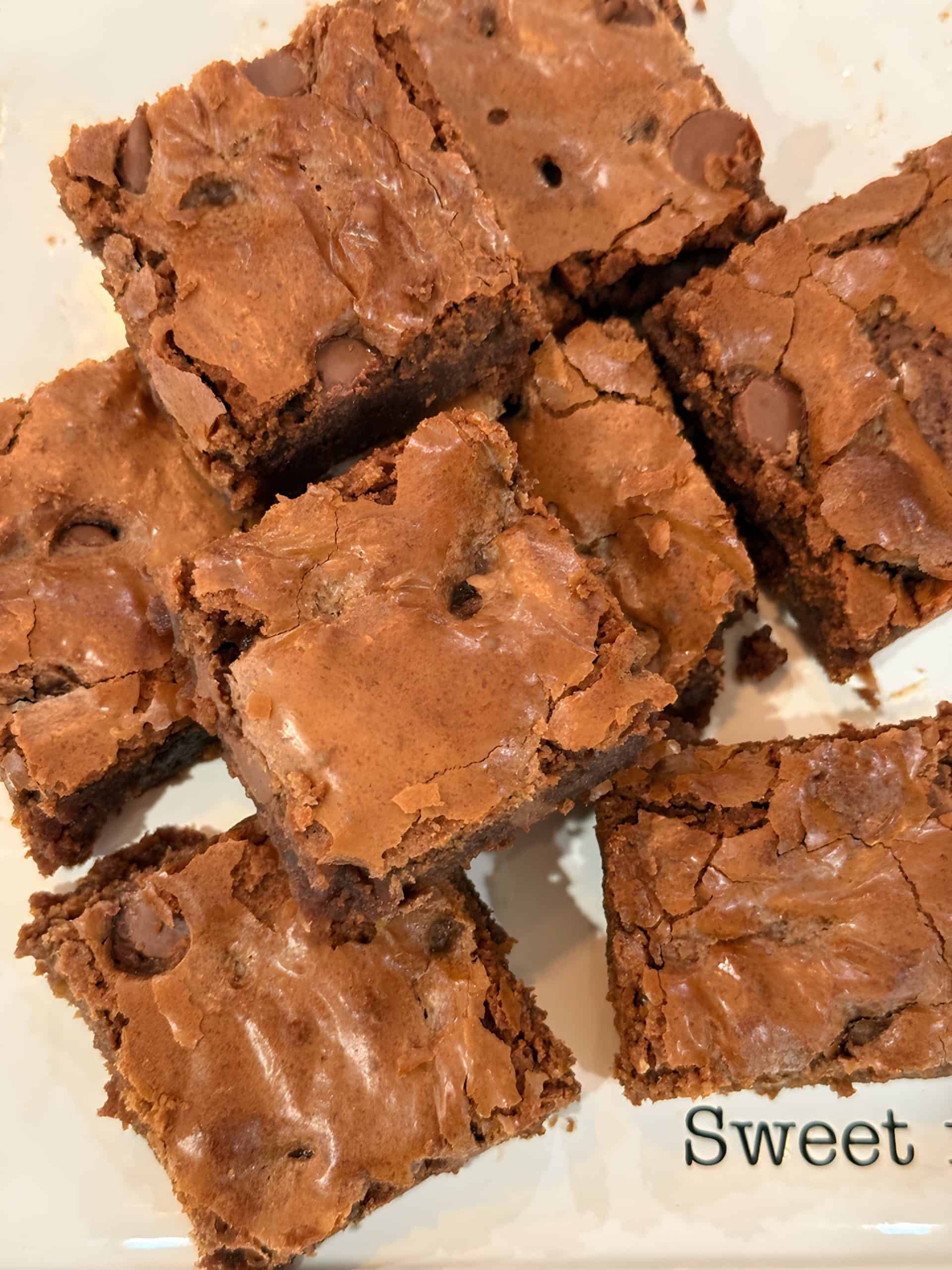 Gooey homemade brownies fresh from the oven on a white plate; Best chocolate brownies recipe ever.