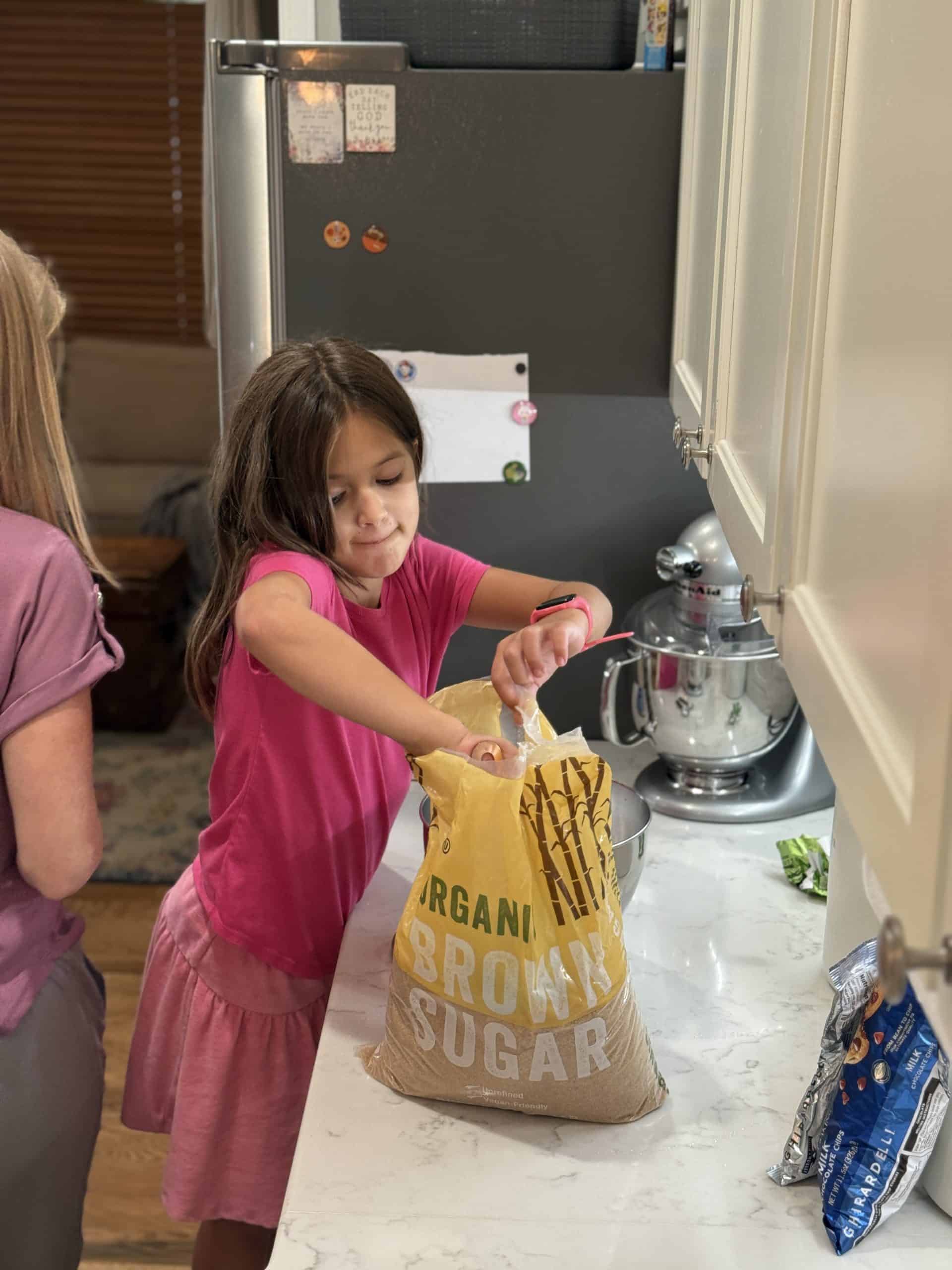 baking brownies in the kitchen with kid, putting brown sugar in mixing bowl