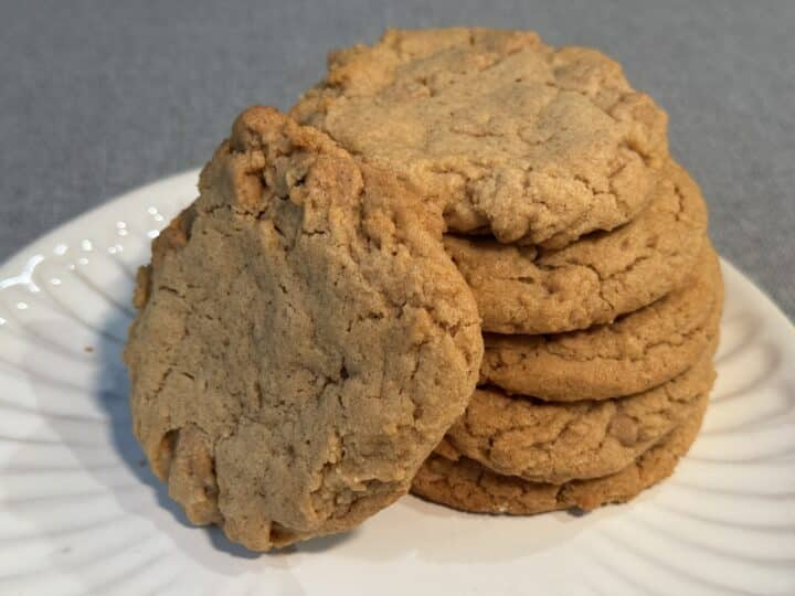 Plate of best peanut butter cookies ready to serve with a glass of milk on a farmhouse table