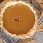 Easy homemade pumpkin pie on Thanksgiving table surrounded by fall decor