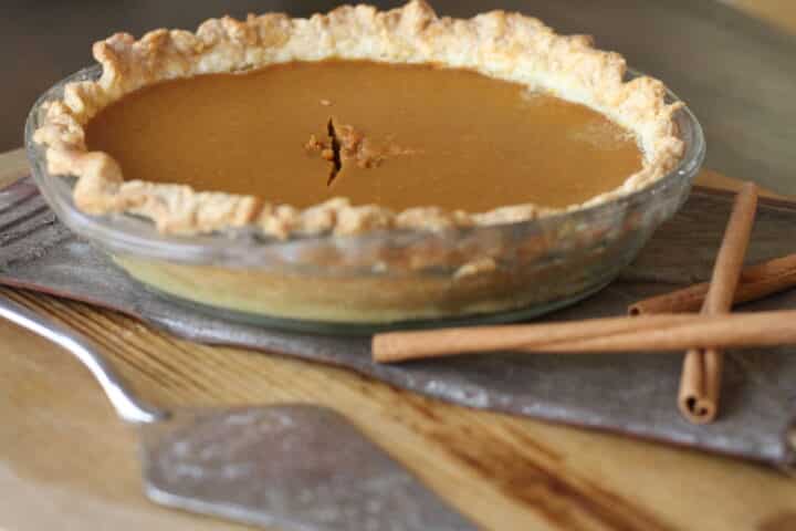 Family-style pumpkin pie cooling on thanksgiving table before serving