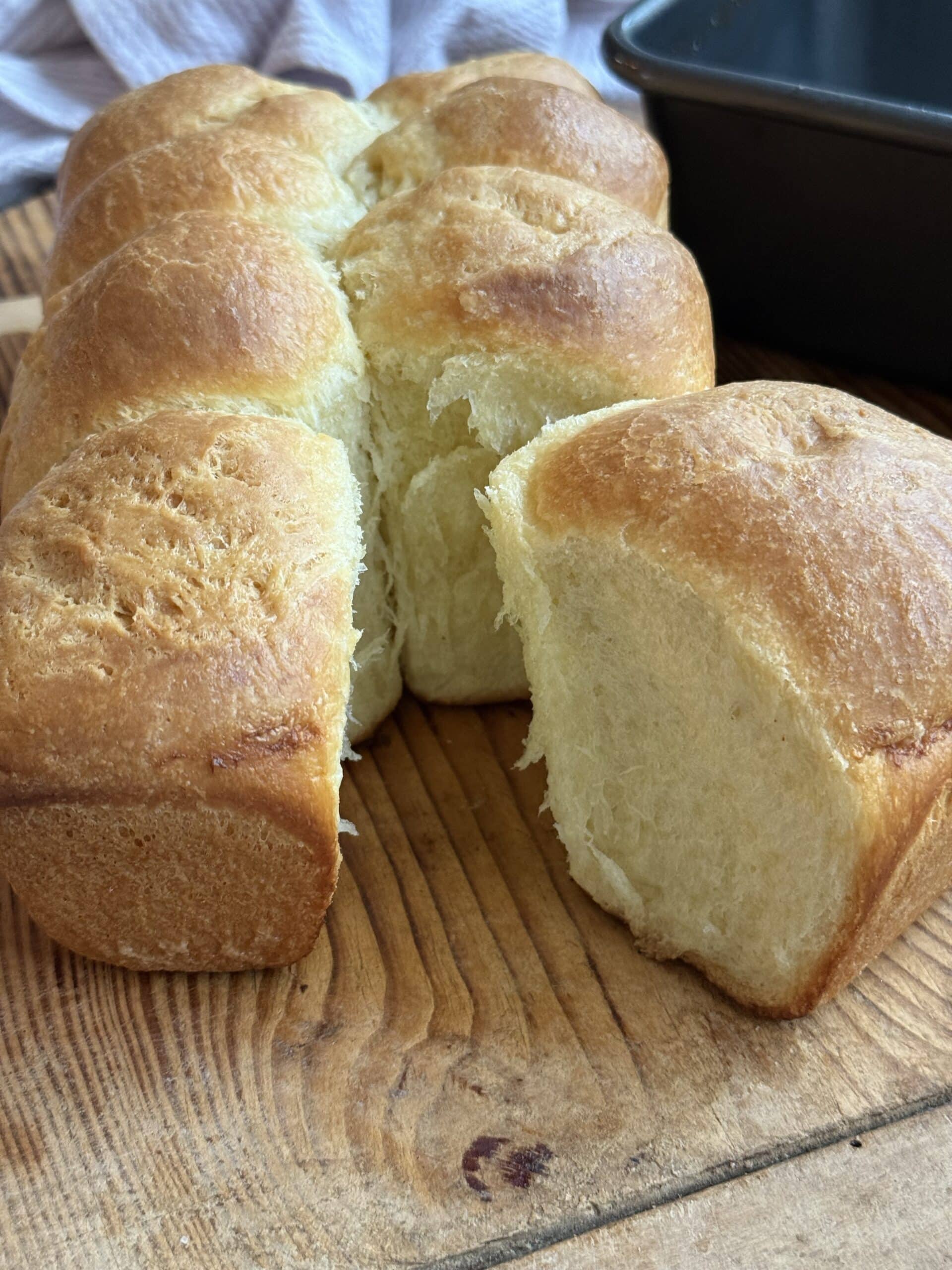 Pull apart brioche bread revealing light, fluffy layers inside