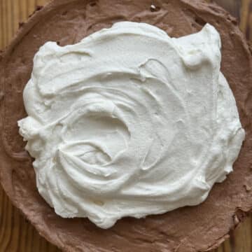 Close-up of creamy chocolate mousse pie with Oreo crust and soft whipped cream topping